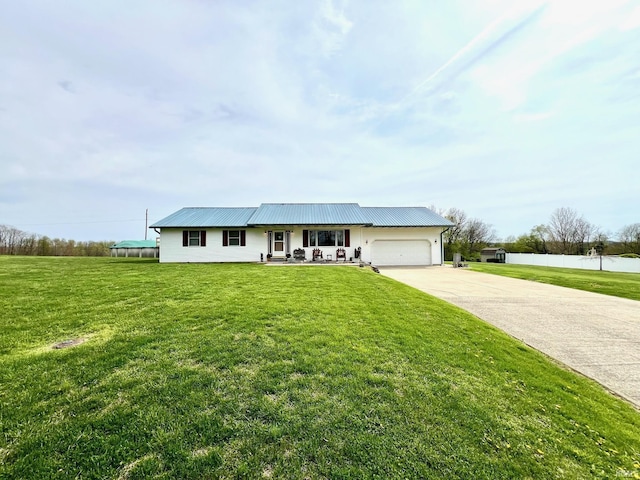 ranch-style house featuring a front lawn, driveway, a porch, metal roof, and an attached garage