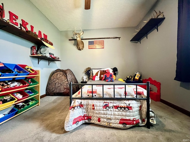 carpeted bedroom featuring baseboards, a textured ceiling, and ceiling fan
