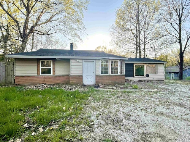 view of front facade with brick siding and fence