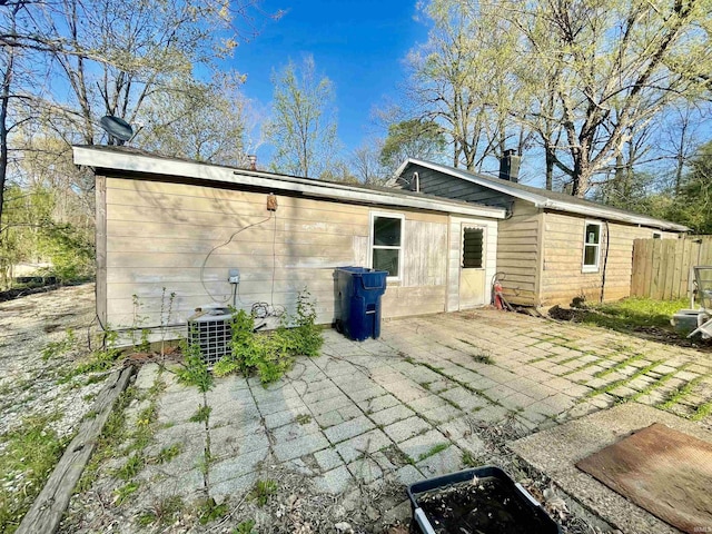 back of house featuring a patio area, central AC, a chimney, and fence