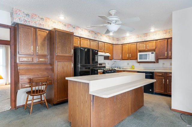 kitchen featuring under cabinet range hood, light countertops, light carpet, black appliances, and brown cabinetry