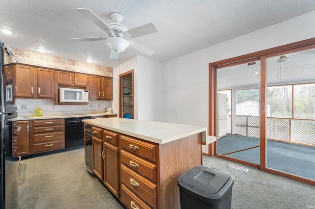 kitchen featuring light countertops, visible vents, white appliances, a textured ceiling, and light colored carpet