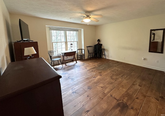 sitting room featuring ceiling fan, baseboards, and wood-type flooring