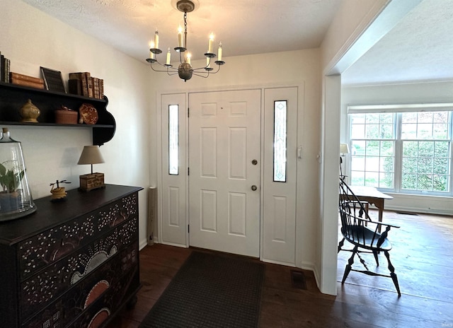 entryway featuring dark wood-style floors and an inviting chandelier