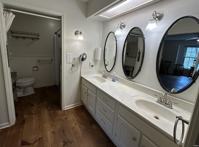 full bathroom featuring hardwood / wood-style floors, a sink, double vanity, and toilet