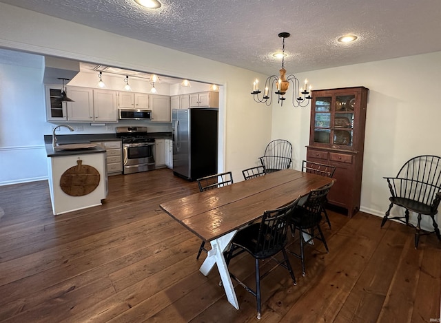 dining area featuring dark wood-style floors, a textured ceiling, and a notable chandelier