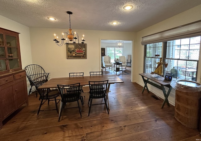dining room with dark wood finished floors, a chandelier, a textured ceiling, and recessed lighting