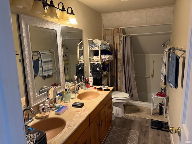 full bath featuring a shower with curtain, wood finished floors, toilet, and a sink