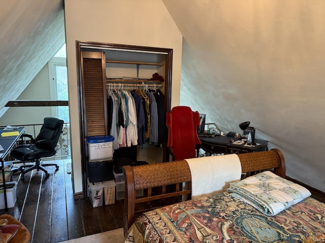 bedroom with hardwood / wood-style floors, a closet, and lofted ceiling