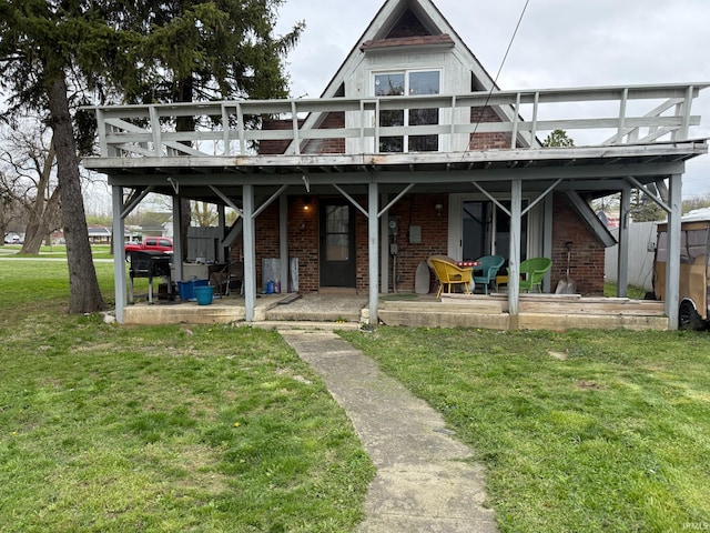 back of house with brick siding, a yard, stairs, and a deck