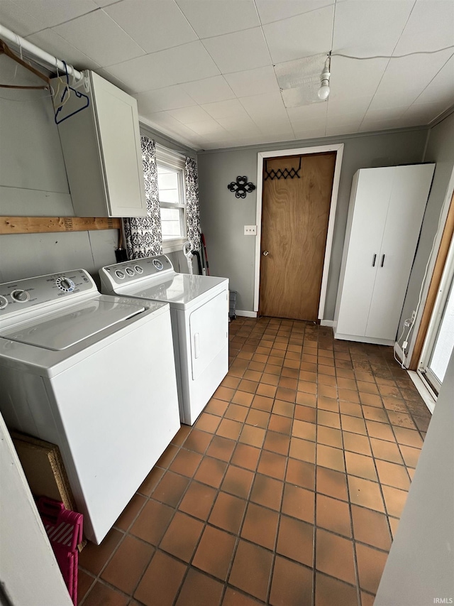laundry area with separate washer and dryer, cabinet space, and dark tile patterned floors