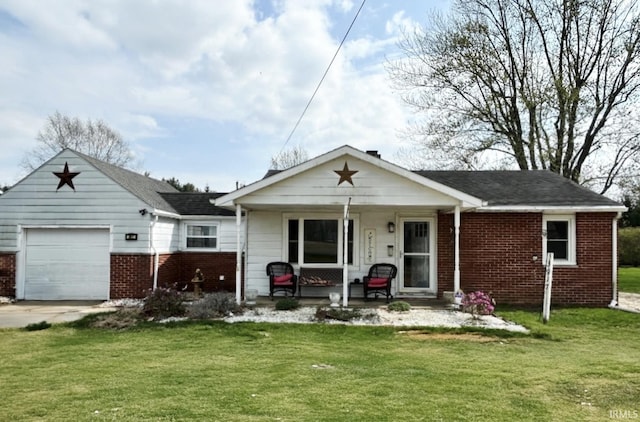 back of house featuring a porch, an attached garage, brick siding, and a yard