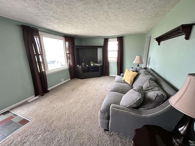 carpeted living area featuring baseboards, visible vents, and a textured ceiling