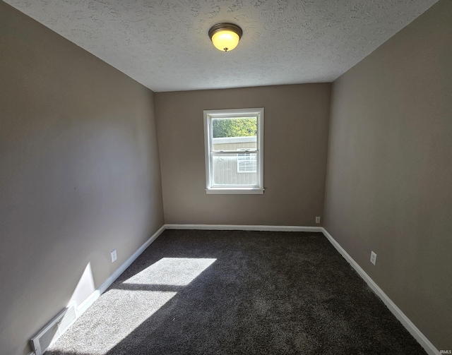 unfurnished room with baseboards, dark colored carpet, and a textured ceiling