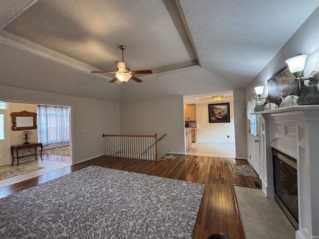 1807 Sterling Oaks Dr, Sellersburg, IN 47172 - unfurnished living room featuring a fireplace with flush hearth, a raised ceiling, light wood-type flooring, and ceiling fan