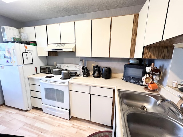 2421 S Brittany Ln, Bloomington, IN 47401 - kitchen with white cabinets, under cabinet range hood, light countertops, a sink, and white appliances