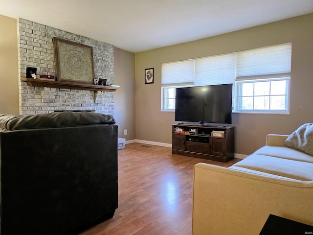 935 Fry Rd, Greenwood, IN 46142 - living room with healthy amount of natural light, wood finished floors, a brick fireplace, and baseboards