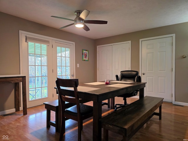 dining room with a ceiling fan, baseboards, a healthy amount of sunlight, and wood finished floors