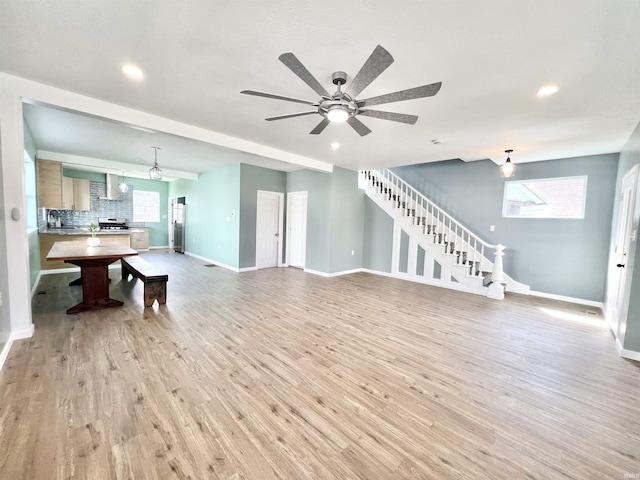 1505 High St, Logansport, IN 46947 - unfurnished living room with a ceiling fan, stairs, light wood finished floors, baseboards, and recessed lighting