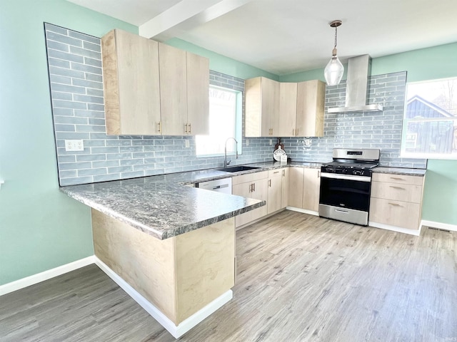 1505 High St, Logansport, IN 46947 - kitchen featuring wall chimney exhaust hood, a peninsula, light brown cabinetry, a sink, and stainless steel gas stove