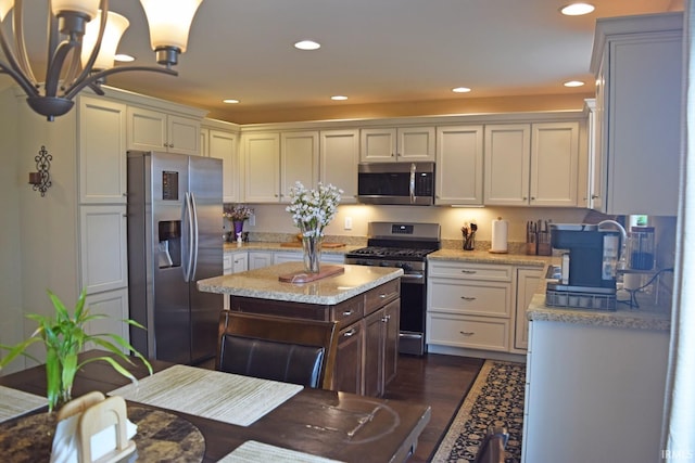 3201 Helmsford Ct, Evansville, IN 47715 - kitchen featuring light stone counters, a chandelier, appliances with stainless steel finishes, dark wood-type flooring, and recessed lighting
