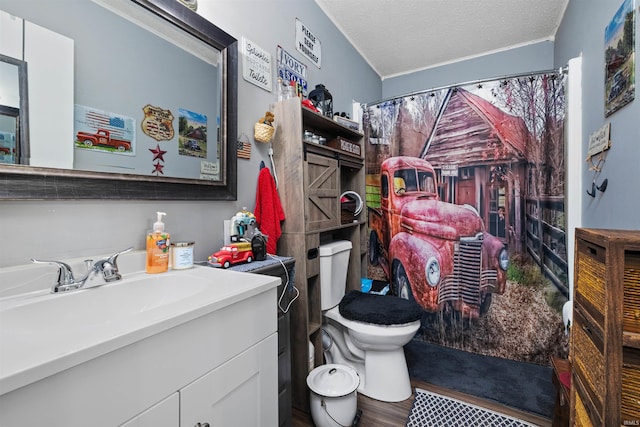 bathroom featuring wood finished floors, toilet, vanity, a shower with curtain, and a textured ceiling