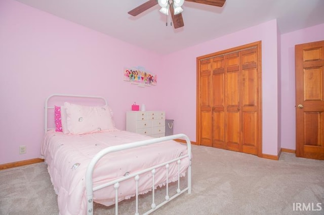 bedroom with baseboards, a closet, light colored carpet, and ceiling fan