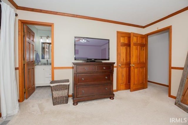 bedroom featuring baseboards, light colored carpet, ornamental molding, and connected bathroom