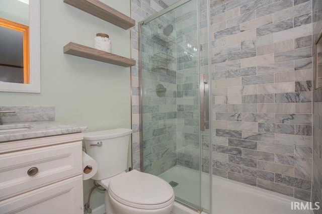 full bathroom with toilet, vanity, and a stall shower