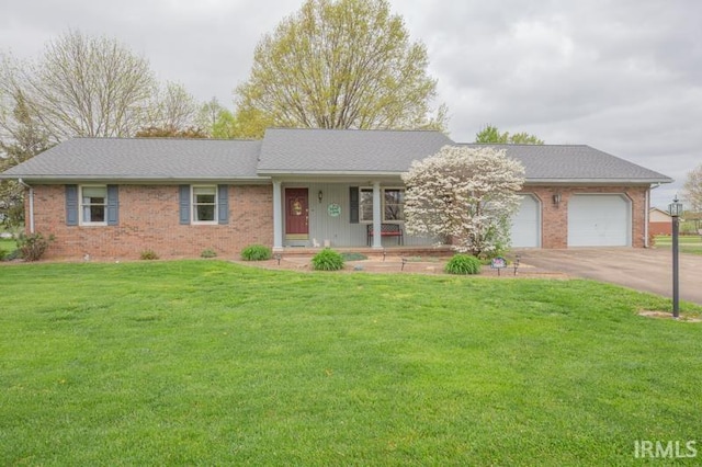 single story home featuring a front lawn, covered porch, concrete driveway, a garage, and brick siding