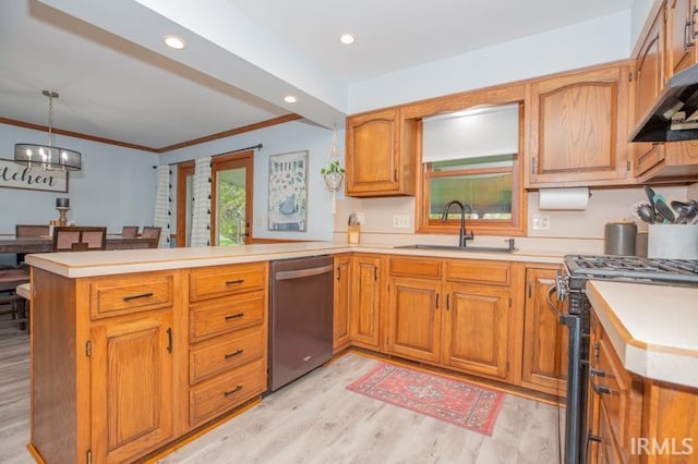 kitchen with a peninsula, light countertops, appliances with stainless steel finishes, and a sink