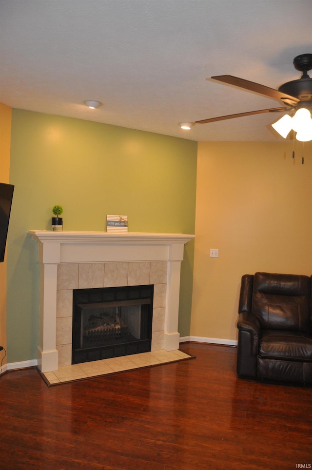 living area featuring baseboards, recessed lighting, wood finished floors, ceiling fan, and a fireplace