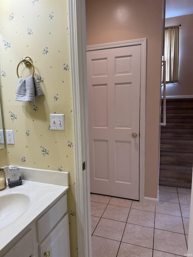 bathroom with baseboards, tile patterned flooring, and vanity