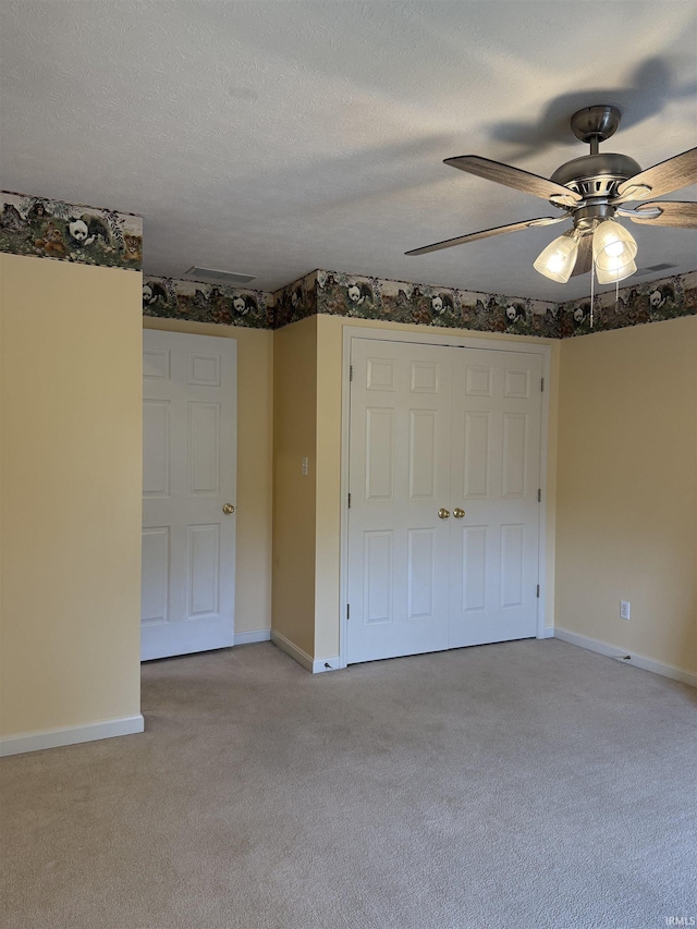unfurnished bedroom with a closet, light carpet, a ceiling fan, and baseboards