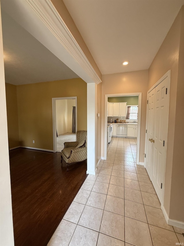 hallway with recessed lighting, baseboards, and light tile patterned floors