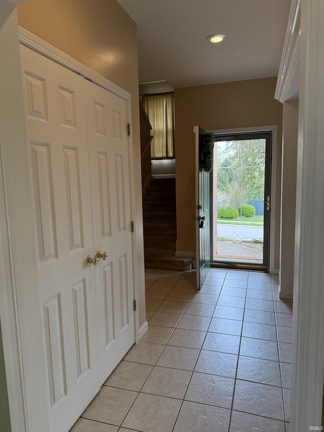 doorway to outside featuring baseboards, recessed lighting, and light tile patterned floors