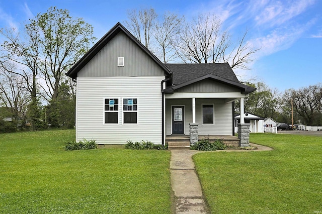 bungalow-style house with roof with shingles, a porch, and a front yard