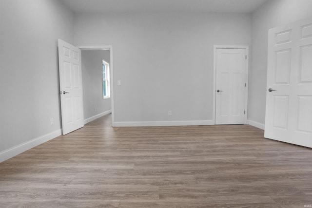 unfurnished bedroom featuring wood finished floors and baseboards