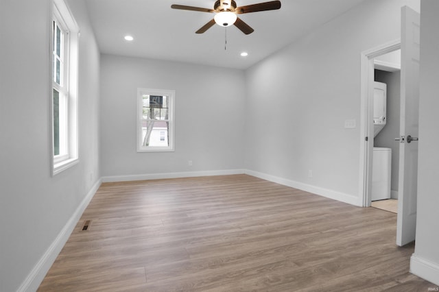 empty room with visible vents, recessed lighting, stacked washer / dryer, light wood-style floors, and a ceiling fan