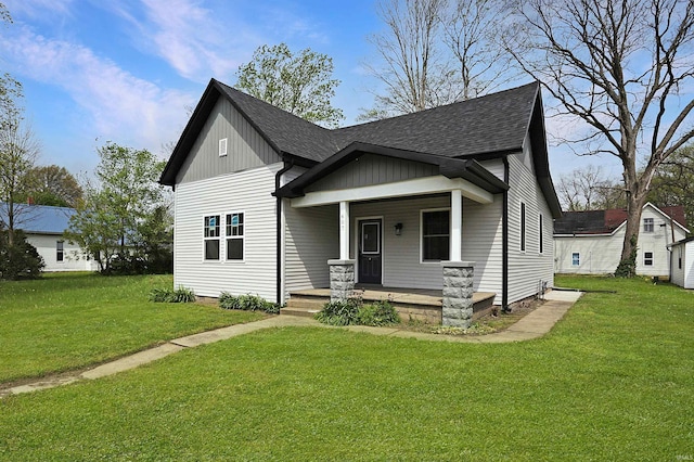 bungalow-style home featuring a porch, a shingled roof, and a front yard