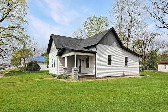 view of front of property featuring a porch, a front lawn, and a shingled roof