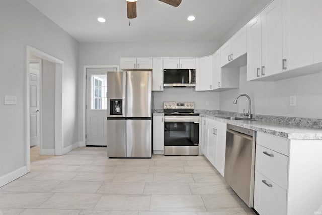kitchen featuring a ceiling fan, a sink, stainless steel appliances, white cabinetry, and recessed lighting