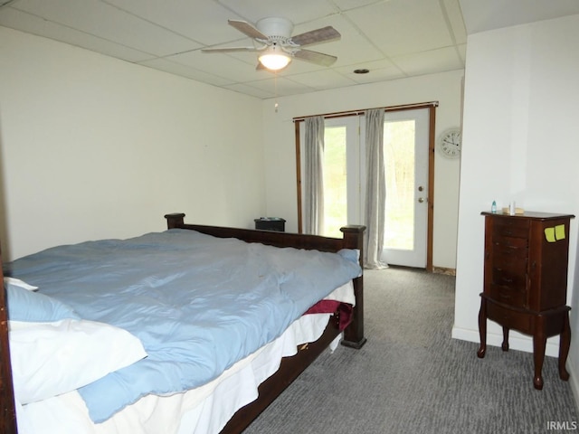carpeted bedroom with a drop ceiling and a ceiling fan