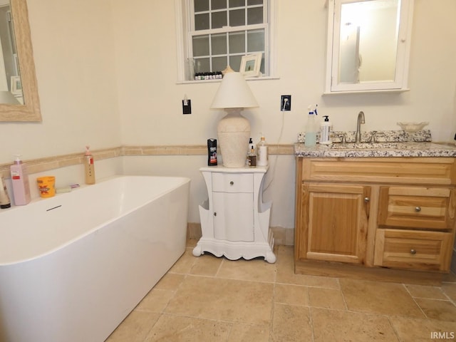 full bathroom with vanity and a freestanding tub