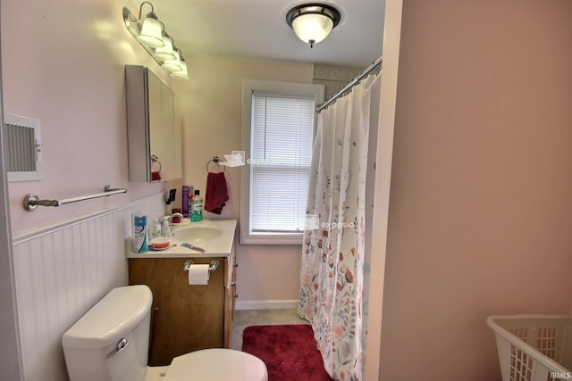 bathroom featuring toilet, vanity, and curtained shower