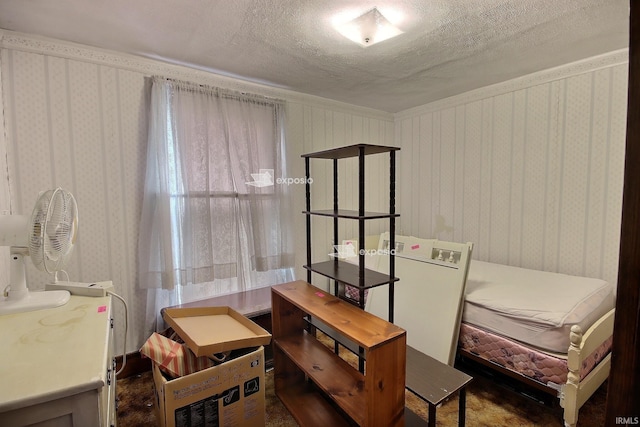 bedroom with wallpapered walls and a textured ceiling