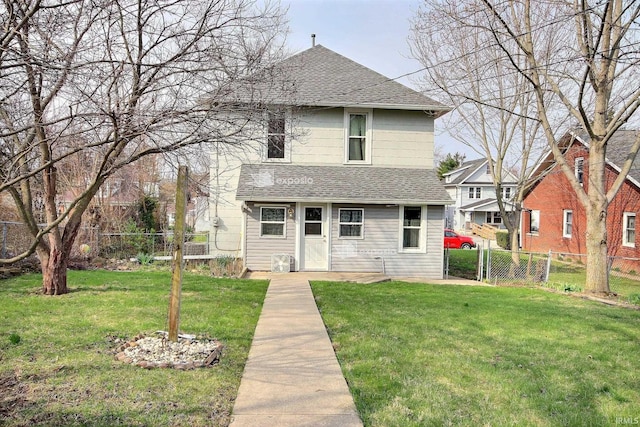exterior space with a front lawn, roof with shingles, and fence