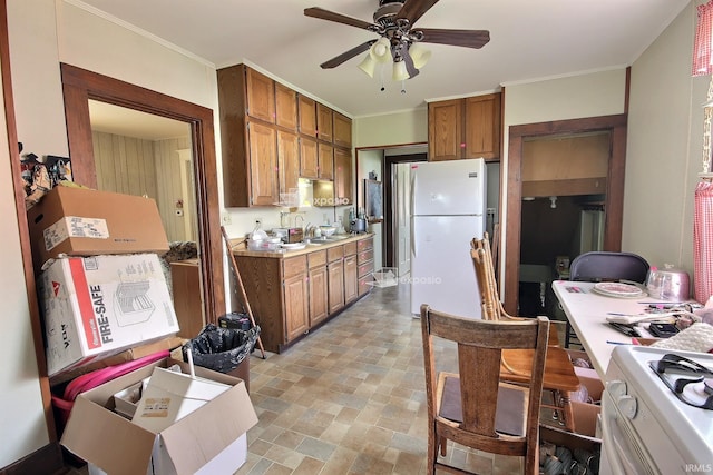 kitchen with a sink, a ceiling fan, white appliances, brown cabinets, and light countertops