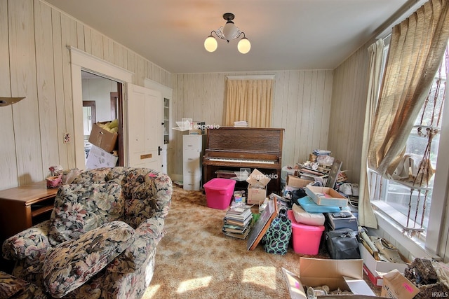 living area with wood walls, carpet flooring, and a chandelier