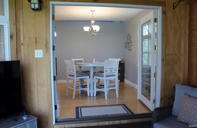 dining room featuring baseboards, a notable chandelier, and wood finished floors